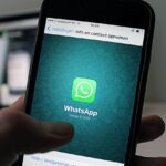 A smartphone displaying the WhatsApp application screen held by a person.